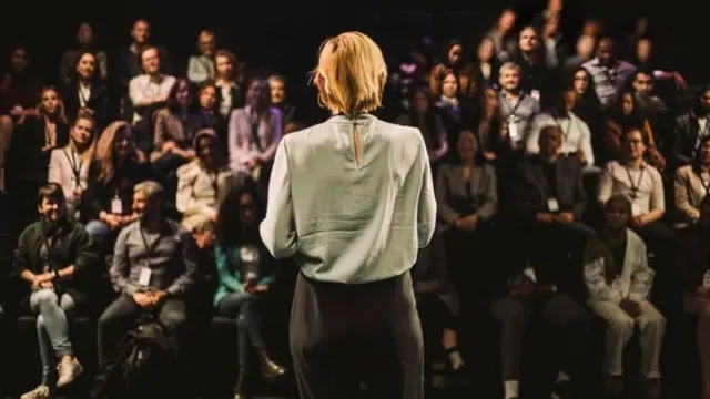 Une locutrice face à un auditoire