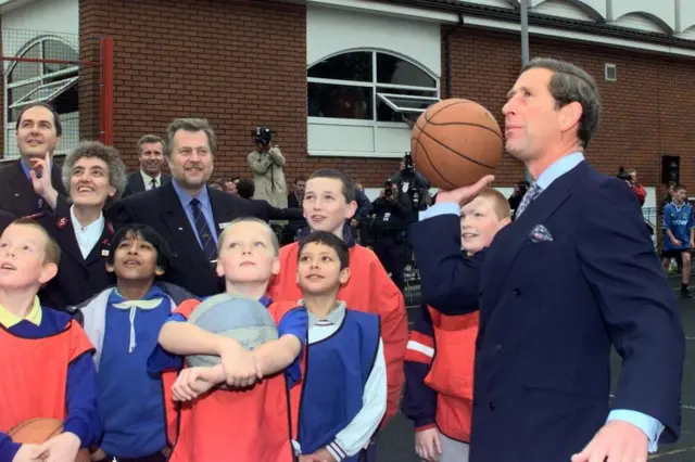 Príncipe de Gales com crianças em um jogo de basquete