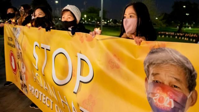 Linda Nguyễn, trái, nạn nhân của các cuộc tấn công chống người châu Á, giơ biểu ngữ chống lại nạn thù hằn kỳ thị ở một sự kiện tại Fountain Valley Sports Park ở Mile Square Park ở Fountain Valley ngày 4/3/2021