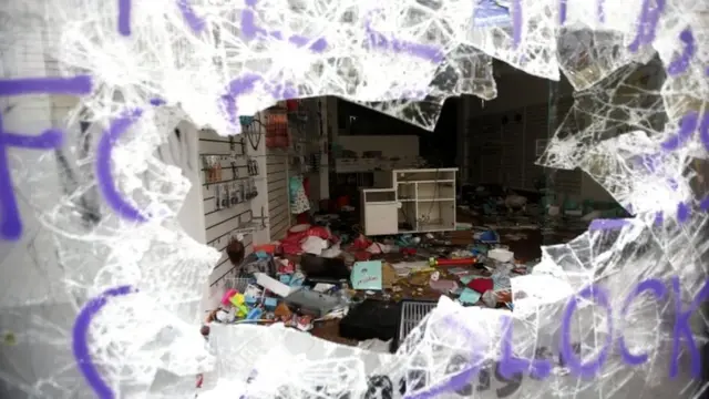 شیشه مغازه‌ای که معترضان اجلاس در شب‌های گذشته شکسته‌اند