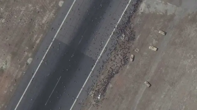 گروه بزرگی از مردم در باند فرودگاه کابل و خودرهای زرهی نیروهای آمریکا - صبح دوشنبه ۲۵ مرداد/اسد