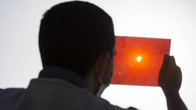 ชายอียิปต์ในกรุงไคโรใช้แผ่นฟิล์มเอ็กซ์เรย์เพื่อชมปรากฏการณ์สุริยุปราคาบางส่วน