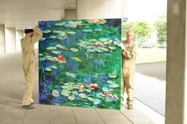 رجلان ينقلان لوحة