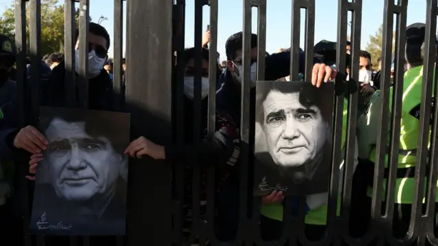 مردم در پشت میلهها ناظر خاکسپاری بودند