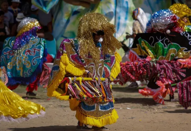 Pessoas com roupas típicas e coloridas