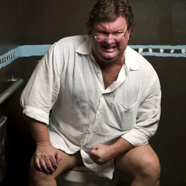 مردی نشسته روی کاسه توالت در حال زور زدن