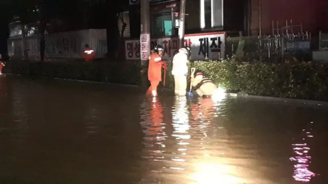 26일 전남 순천시의 한 도로가 침수됐다는 신고를 받고 출동한 소방대원들이 배수구 정비를 하고 있다