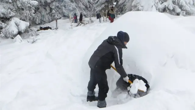 Людина копає нору в снігу