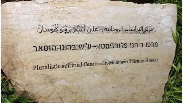 ફાધર બ્રુનો હુસ્સરની યાદમાં ઊભા કરાયેા પ્લુરાલિસ્ટિક સ્પિરિચુઅલ સેન્ટર બહાર લગાવાયેલ તખ્તીની તસ્વીર