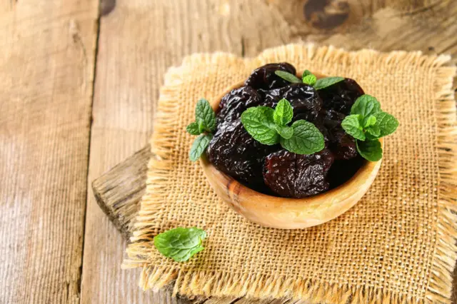 Prunes séchées avec ds feuilles de menthe dans un bol