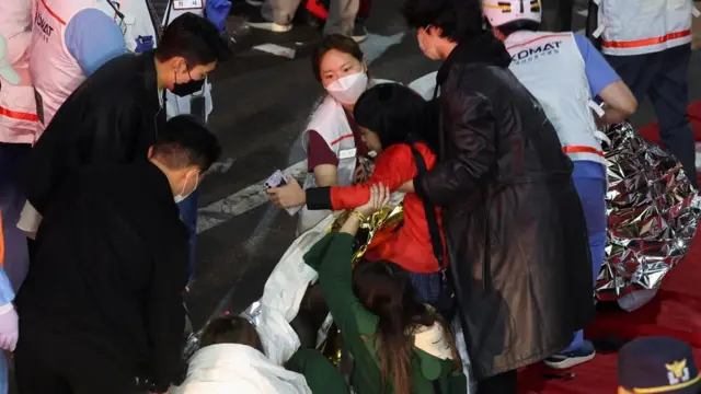 ভিড়ে চাপা পড়ে আহত একজনকে চিকিৎসা দেয়া হচ্ছে।