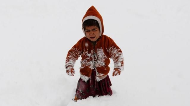 Мальчик под снегом в Афганистане