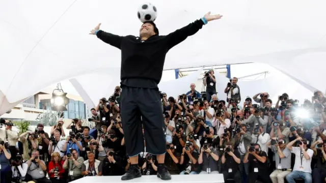 Maradona siendo fotografiado.