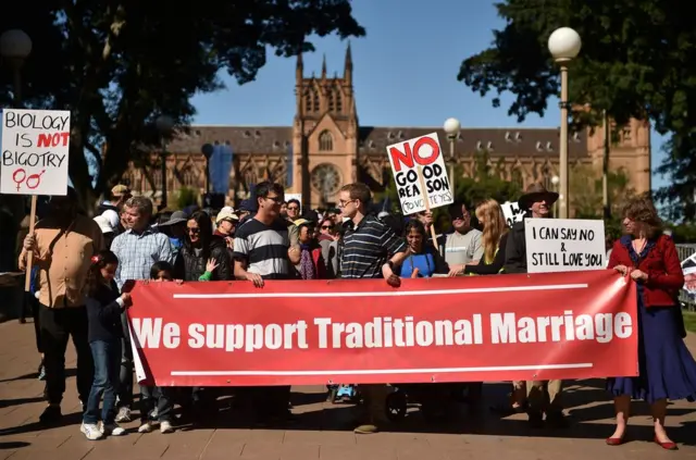 This picture taken on September 9, 2017 shows protesters holding up banners at an anti same-sex marriage rally in Sydney. As Australia prepares for a contentious vote on legalising gay marriage set to kick off on September 12, fierce divisions have emerged within the church, with many Christians disregarding traditional religious views as outdated. / AFP PHOTO / Peter PARKS / TO GO WITH Australia-politics-marriage-rights-gay-religion, FOCUS by Daniel DE CARTERETPETER PARKS/AFP/Getty Images