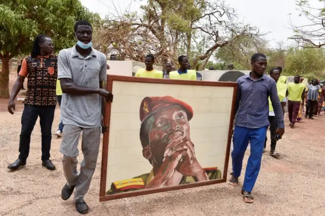 People carry a portrait of Thomas Sankara to a memorial site.