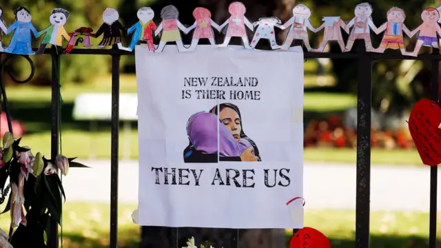 A poster hangs at a memorial site for victims of Friday"s shooting, in front of Christchurch Botanic Gardens in Christchurch, New Zealand