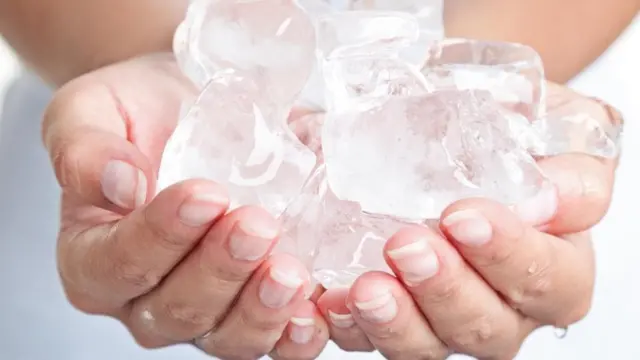 Una persona con cubos de hielo en las manos