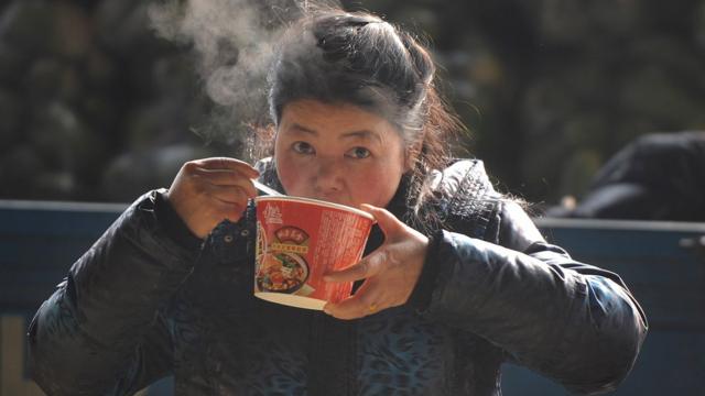 Woman eats instant noodles