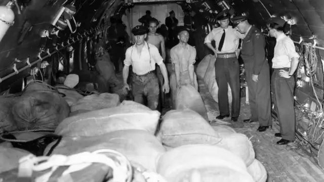 Жүк ташыган америкалык учактан ун түшүрүп жаткан учур. Берлиндеги Гатов аэропорту, 1948-жыл 23-август.