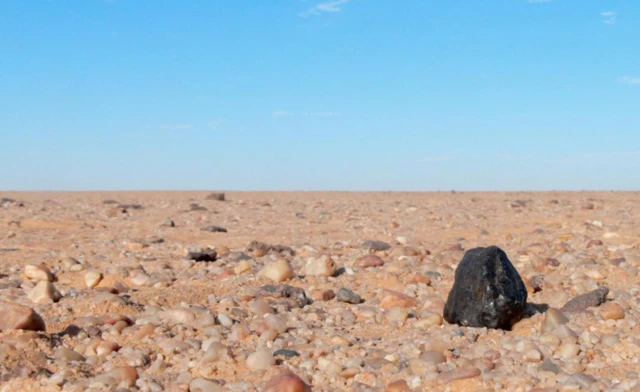 ชิ้นส่วนหนึ่งของอุกกาบาต Almahata Sitta (ก้อนสีดำทางขวา) ที่พบในทะเลทรายของซูดานเมื่อปี 2008