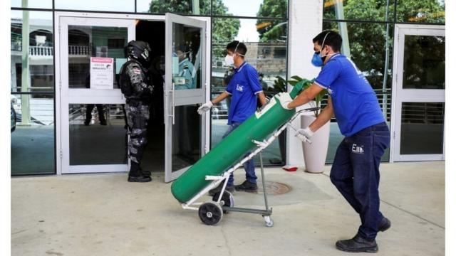 Homem leva cilindro de oxigênio para hospital em Manaus