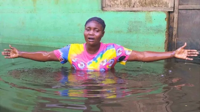 Shiphrah Timbiri chantant dans l'eau d'une inondation dans la municipalité d'Ogbia, État de Bayelsa, Nigeria - Novembre 2022