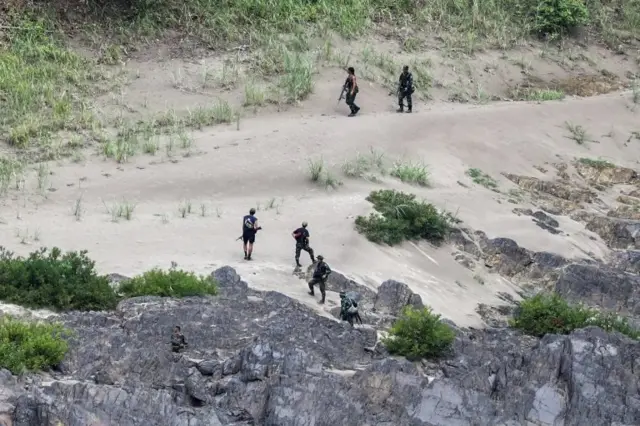 Ethnic minority Karen troops approach a Myanmar army outpost near the Thai border, as seen from the Thai side on the Thanlwin, also known as Salween, riverbank in Mae Hong Son province, Thailand, April 28, 2021.