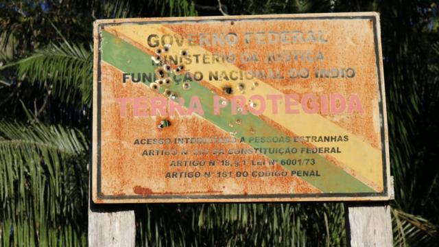 Placa crivada de balas na fronteira de uma reserva indígena no Brasil