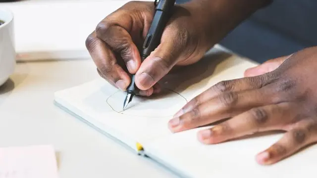 Hand of pesin wey dey write.