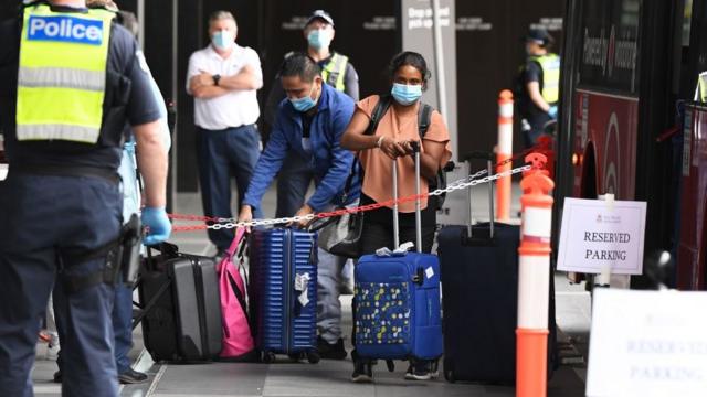 Returning Australian passengers shepherded by police into hotel quarantine