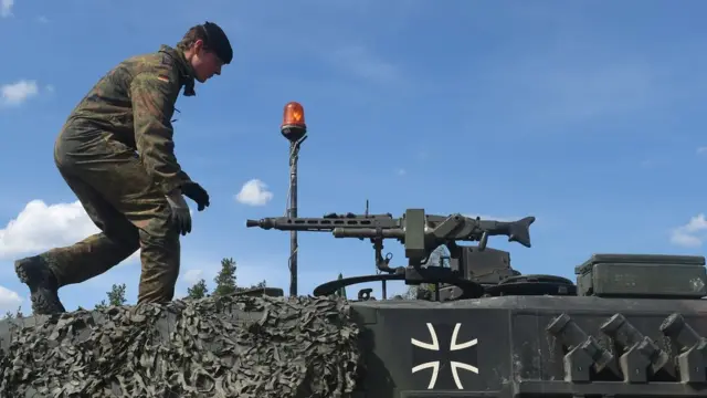 Германский танкист на башне танка Leopard 2, который вооружен пулеметом MG3.