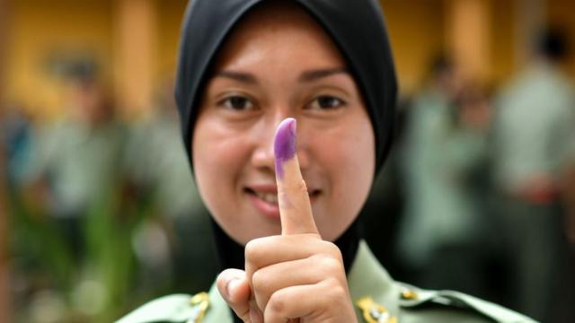 期日前に投票し、投票済を示す消えないインクで染まった指を掲げるマレーシア軍の兵士（5日、クアラルンプール）