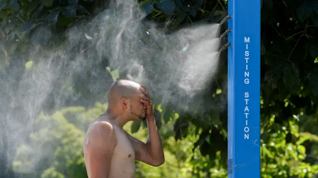 رجل من فانكوفر يستخدم بخاخا عموميا نصبته السلطات لمساعدة السكان في مواجهة موجة الحر التي تمر بها المدينة. وصلت درجة الحرارة إلى أعلى مستوياتها إذ بلغت 49.5 درجة مئوية