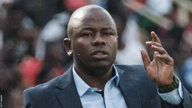 L'entraîneur de football William Muluya en costume à la tête du club kenyan Kariobangi Sharks contre le club anglais de Premier League Everton.