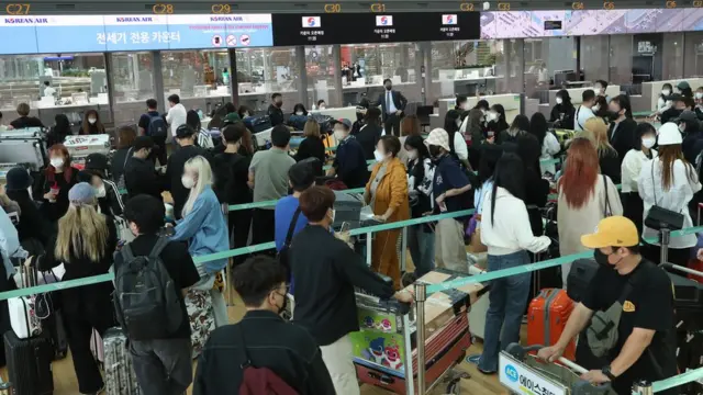 여행객들이 공항 출국장에 줄 서 있다