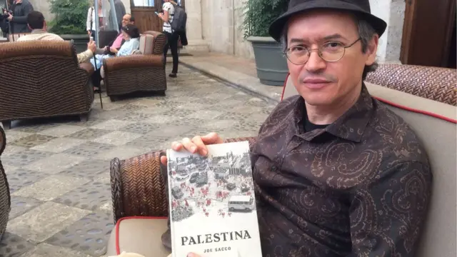 Joe Sacco con una ejemplar de "Palestina".