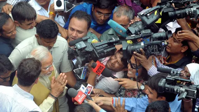 मीडिया के कैमरों से घिरे प्रधानमंत्री नरेंद्र मोदी