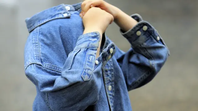 Niño se cubre rostro con chaqueta