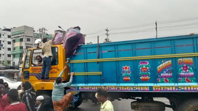 সাভারের একটি সড়কে এভাবেই খোলা ট্রাকে করে বাড়ি ফিরছেন শ্রমিকরা 