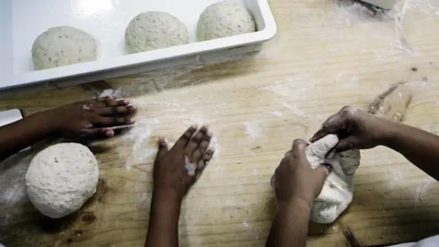 Piekarze w piekarni The Bakers Dozen w Mumbaju w Indiach wyrabiają ciasto chlebowe ręcznie