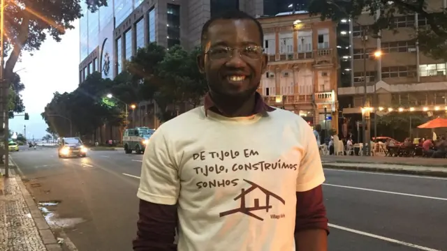 Em rua do Riorodadas gratis cadastroJaneiro, Jac-Ssone Alerte posa para foto sorrindo e exibindo camisa com os dizeres 'De tijologrodadas gratis cadastrotijolo, construímos sonhos'