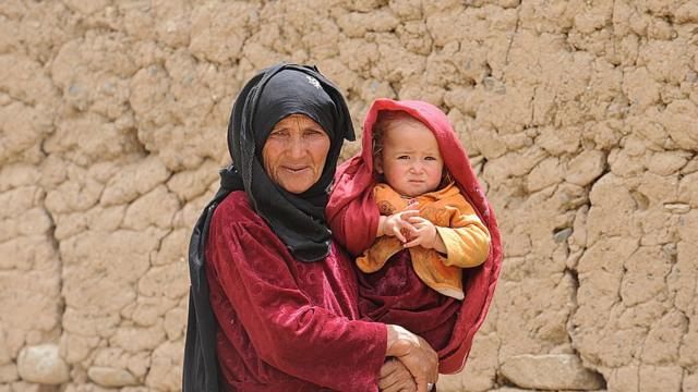 Idosa carrega bebê no Afeganistão