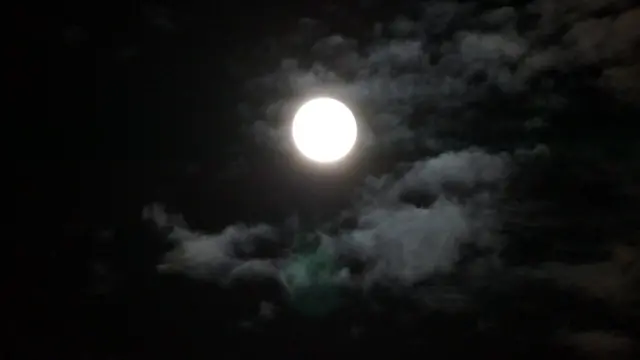 Bright moon shining with clouds