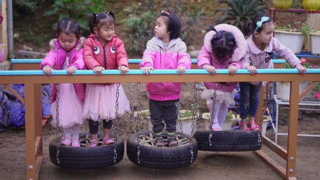 Vietnamese girls play on a obstacle course made of tyres.