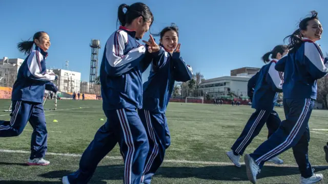 A schoolgirl gestures and others laugh as they jog around the school sports field during a physical education class at Tokyo Korean Junior and Senior High School on January 22, 2019 in Tokyo, Japan