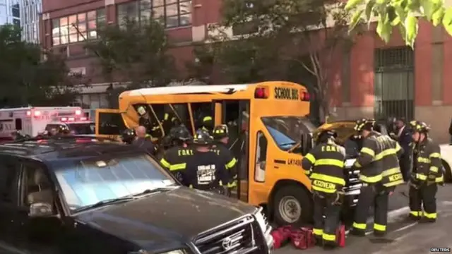 Authorities attend to a school bus damaged in the truck attack in New York City