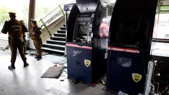 Na foto, dois caixas eletrônicos quebrados em uma estação de metrô