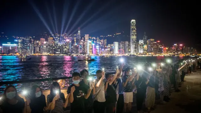 Люди держатся за руки на набережной