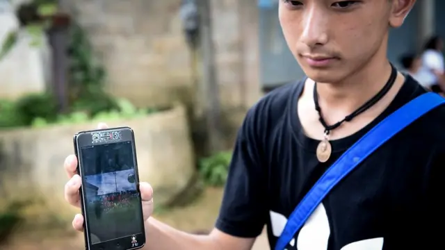 ธนัญชัย แสงตันยกมือโชว์เพื่อนของเขาในทีมฟุตบอลเดียวกันให้ผู้สื่อข่าวดู