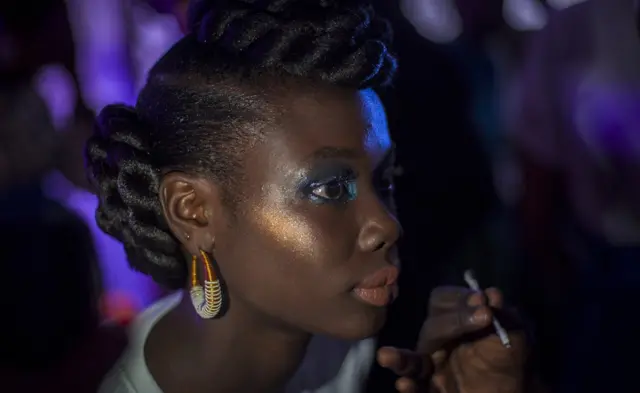 Une mannequin se maquille dans les coulisses de la Semaine de la mode de Dakar, à Dakar, au Sénégal.